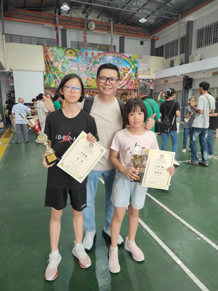 Teacher with students holding competition trophies and certificates