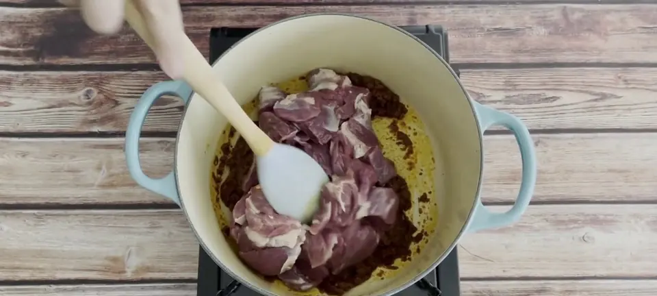 Mutton added to rendang paste in a pot