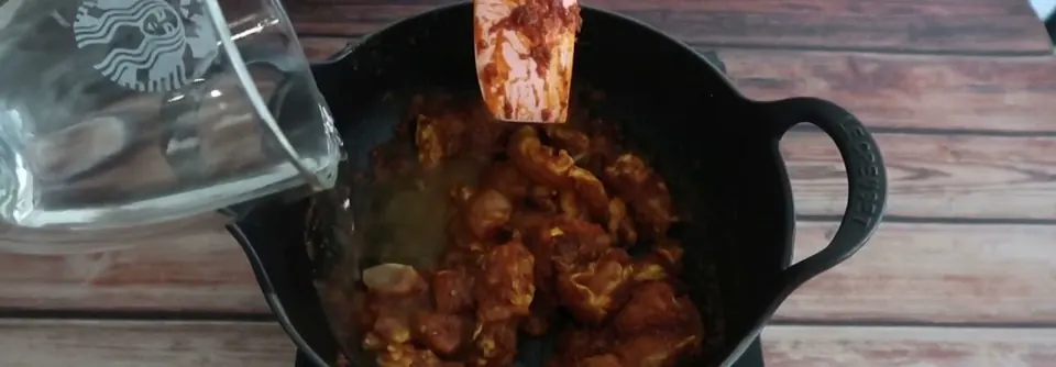 A quarter cup of water poured into satay chicken