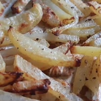 Close-up of hand cut fries with cracked black pepper