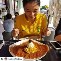 A guest at a table with a large crêpe topped with ice cream
