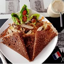 Buckwheat galette folded into triangles with a side salad of lettuce and tomato